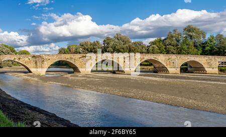 Die alte Ponte Buriano über dem Fluss Arno im Landkreis Arezzo, Toskana, Italien, an einem sonnigen Tag Stockfoto