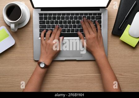 Aufnahme von weiblichen Händen, die am Büroschreibtisch auf dem Laptop tippten. Stockfoto