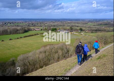 Spaziergänger auf dem Wolstonbury Hill im South Downs National Park in West Sussex, England, mit Blick auf Danny House und Woolstonbury Vineyard. Stockfoto