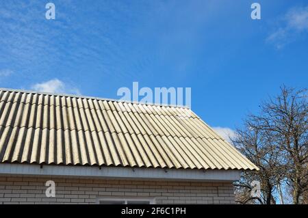 Gefährliche Asbest-Dachziegel auf dem Hausdach. Stockfoto
