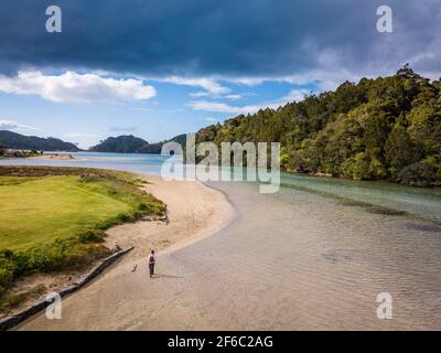 Reisende, die durch klares, flaches Wasser am Flussufer wandern. Luftaufnahme von Neuseeland fantastische Landschaften und Landschaften. Stockfoto