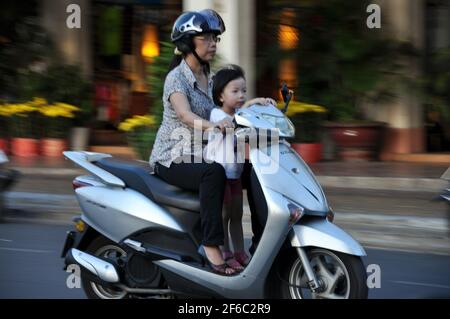 CAN THO, VIETNAM - 17. FEBRUAR 2013: Einheimische mit Motorrad fahren in der größten Stadt des Mekong-Deltas, wo der Verkehr oft überläuft Stockfoto