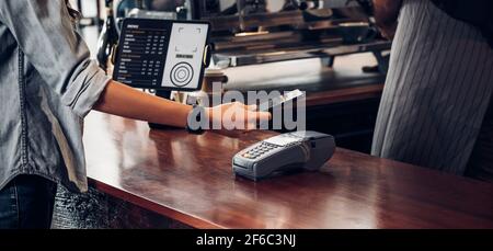 Kontaktloses Bezahlen des Kunden für Getränke mit mobilem Phon im Café Theke Bar, Verkäufer Coffee Shop akzeptieren Zahlung per mobile.New normalen Lebensstil Konzept Stockfoto