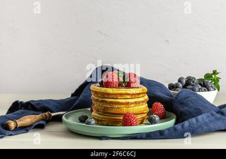 Frühstückskonzept mit amerikanischen Pfannkuchen mit Himbeeren, Minze und Blaubeeren Stockfoto
