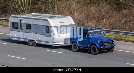 2001 Blue SWB Land Rover 90 Defender Towing Hobby VIP 660 Zweiachs Caravan; Reisemobile, Wohnmobil auf britischen Straßen, Wohnmobil-Freizeitfahrzeug, Familienurlaub, Caravanette Urlaub, Touring Caravan Urlaub, VEREINIGTES KÖNIGREICH Stockfoto