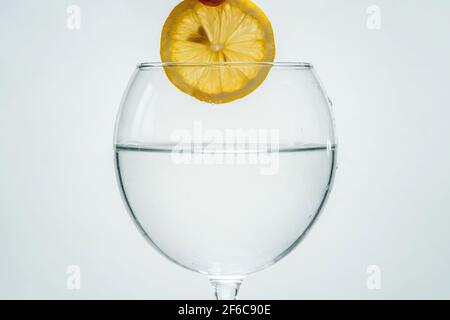 Frisches, klares Wasser mit Zitrone auf weißem Grund reinigen Stockfoto