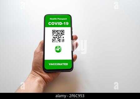 Geimpfte Person mit digitalen Gesundheitspass-App im Handy Für Reisen während der covid-19 Pandemie Stockfoto