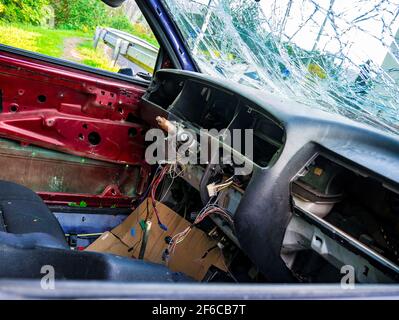 Blick in das zerstörte Innere des verlassenen Autowracks Der Rand des Parkplatzes Stockfoto