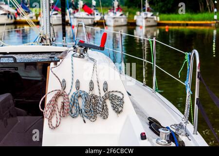 Detail eines Segelbootdecks mit einer Winde und Nylonseilen. Segelyacht Rigging Ausrüstung Stockfoto