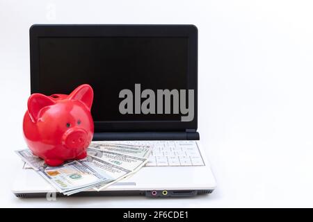 Laptop mit leerem schwarzen Bildschirm, rotem Sparschwein und Dollar auf weißem Hintergrund. Online-Geschäft, Internet-Banking-Konzept. Online einkaufen, Online l Stockfoto