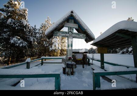 Februar 2021 - Kimzha. Ein verehrtes antikes Holzkreuz mit dem Bild Jesu und einem Gebet. Straßenkreuze. Russland, Archangelsk Region, Mezensky di Stockfoto