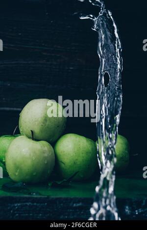Wasser spritzt auf grünen Äpfeln Stockfoto