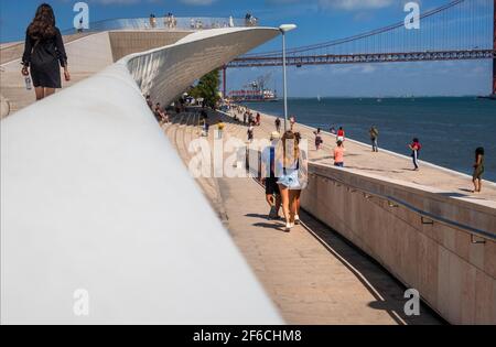 Museum für Kunst, Architektur und Technologie mit 25. April Brücke im Hintergrund über den Fluss Tejo, Belem, Lissabon, Portugal Stockfoto