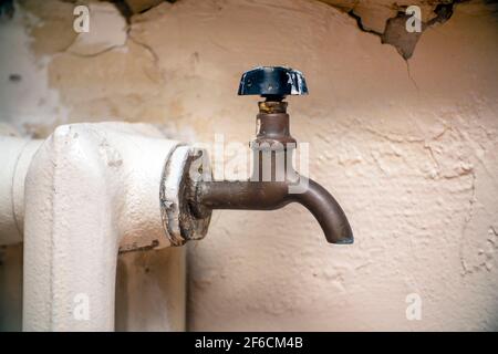 Wasserhahn zum Ablassen von Wasser auf einer alten gusseisernen Dampfheizung Batterie Stockfoto