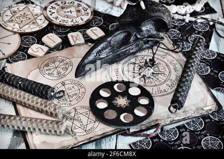 Grunge Stillleben mit Hexentagebuch mit Wiccan-Symbolen auf Seiten, Kerzen, Holzkreis mit Mondphasen. Esoterischer, gotischer und okkulter Hintergrund, Hall Stockfoto