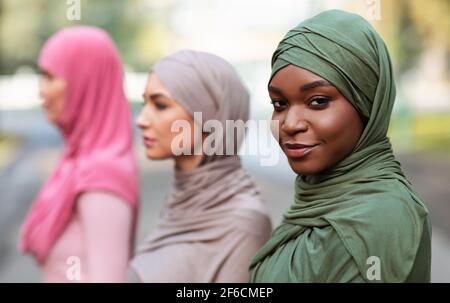 Schwarz Muslimische Frau Posiert Mit Verschiedenen Islamischen Damen Im Freien Stehen Stockfoto