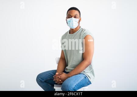 Covid-19 Geimpfter Afroamerikanischer Mann Posiert Mit Maske, Weißer Hintergrund Stockfoto