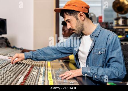 Stock Foto von Hipster Mann mit Panel-Steuerung in professionellen Musikstudio. Stockfoto