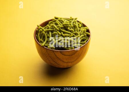 Spinat oder Palak sev sind knusprig gebratene herzhafte Nudeln. Hausgemachte dicke und dünne grüne Shev oder namkeen ist ein klassischer indischer Snack. Serviert in einer Schüssel oder pl Stockfoto