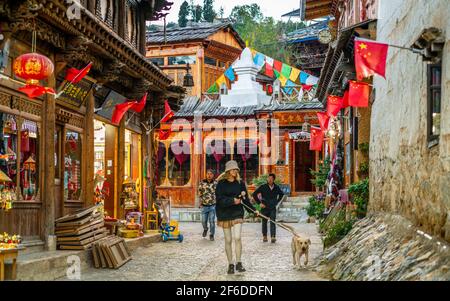 Shangrila China , 10 October 2020 : Alte tibetische Häuser Straßenansicht mit Menschen in der Dämmerung in Dukezong Altstadt in Shangri-La Yunnan China Stockfoto