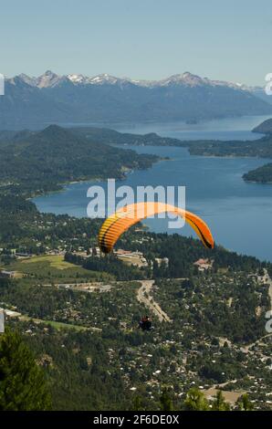 Gleitschirmflug-Szene über der Stadt bariloche, mit See und Bergen, in vertikaler mit Kopierraum Stockfoto