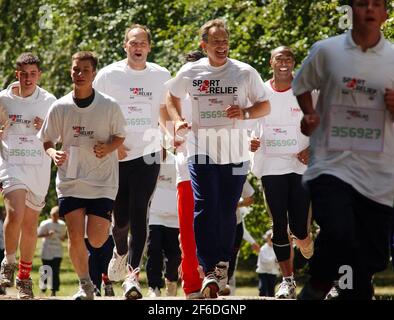 TONY BLAIR WIRD VON SIR STEVE REDGRAVE, COLIN JACKSON UND SCHULKINDERN IN EINEM SPEZIELLEN MILE RUN AUF DEM GELÄNDE VON CHEQUERS UNTERSTÜTZT RELIEF,9/7/04 PILSTON Stockfoto