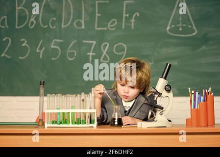 Technologie- und Wissenschaftskonzept. Kind studiert Biologie und Chemie in der Schule. Schulbildung. Erforschen Sie biologische Moleküle. Kleinkind Genie Baby. Junge Stockfoto