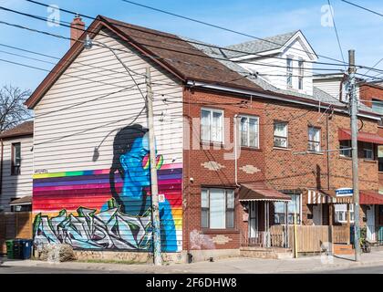 Stadtkunst in einer Holzwand eines alten Hauses in der Bathurst Street, Toronto, Kanada, 2021 Stockfoto