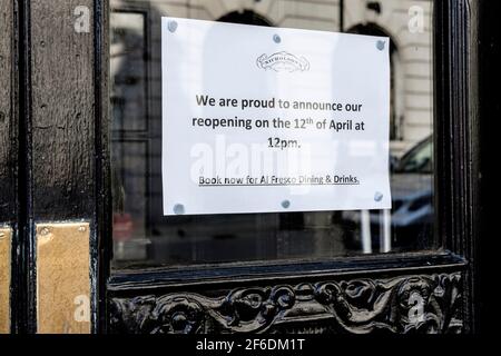 Das Fenster des Pubs, das seine Wiedereröffnung ankündigt, wurde nach der Lockerung der Covid-Beschränkungen durch die britische Regierung geöffnet, die es den Pubs, Restaurants und Cafés in England erlaubt, erst ab dem 12th. April 2021 für den Außendienst wieder zu öffnen. London, Großbritannien Stockfoto