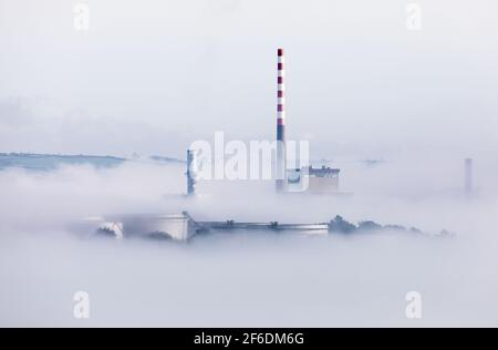 Ahada, Cork, Irland. 31st. März 2021.die Morgensonne beginnt, den Meeresnebel zu entkeichen, der die Lagertanks der Ölraffinerie und des Elektrizitätswerks in Ahada, Co. Cork, Irland, umgibt. - Credit; David Creedon / Alamy Live News Stockfoto