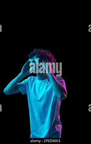 Porträt des kaukasischen Mann isoliert auf dunklen bunten Hintergrund in Neonlicht Stockfoto