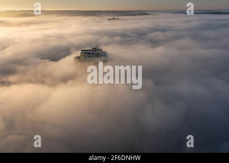 Am frühen Morgen bedeckt Nebel den Ohio River über der Innenstadt von Cincinnati Und Kentucky, während die Sonne Gebäude und Brücken durchleuchtet Die Nebelwolken Stockfoto