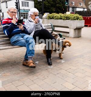Epsom Surrey London, 31 2021. März, Senior man Frau Paar sitzt auf einem Sitz im Freien oder Bank entspannen mit Kaffee Stockfoto