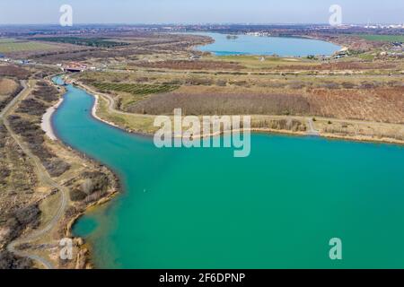 31. März 2021, Sachsen, Markkleeberg: Der Kanal zwischen Markkleeberger See (hinten) und Störmthaler See ist mit einer Pfahlwand verschlossen. Risse im Kanaldamm zwischen den Gewässern erfordern sofortige Sicherungsmaßnahmen. Der 850 Meter lange Störmthal-Kanal verbindet die beiden Seen - die Schleuse, die jetzt von Rutschen im Böschung betroffen ist, kompensiert die Differenz von vier Metern im Wasserstand der Gewässer. Experten zufolge würde ein vollständiger Einsturz zu großflächigen Überschwemmungen führen - in den nördlichen Stadtgebieten von Markkleeberg bis Leipzig. Jetzt tauchen, surfen, sa Stockfoto