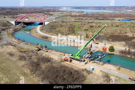 31. März 2021, Sachsen, Markkleeberg: Der Kanal zwischen Markkleeberger See (hinten) und Störmthaler See ist mit einer Pfahlwand verschlossen. Risse im Kanaldamm zwischen den Gewässern erfordern sofortige Sicherungsmaßnahmen. Der 850 Meter lange Störmthal-Kanal verbindet die beiden Seen - die Schleuse, die jetzt von Rutschen im Böschung betroffen ist, kompensiert die Differenz von vier Metern im Wasserstand der Gewässer. Experten zufolge würde ein vollständiger Einsturz zu großflächigen Überschwemmungen führen - in den nördlichen Stadtgebieten von Markkleeberg bis Leipzig. Jetzt tauchen, surfen, sa Stockfoto