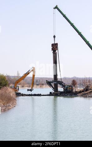 31. März 2021, Sachsen, Markkleeberg: Der Kanal zwischen Markkleeberger und Störmthaler ist mit einer Pfahlwand verschlossen. Risse im Kanaldamm zwischen den Gewässern erfordern sofortige Sicherheitsmaßnahmen. Der 850 Meter lange Störmthal-Kanal verbindet die beiden Seen - die Schleuse, die jetzt von Rutschen im Böschung betroffen ist, kompensiert die Differenz von vier Metern im Wasserstand der Gewässer. Experten zufolge würde ein vollständiger Einsturz zu großflächigen Überschwemmungen führen - in den nördlichen Stadtgebieten von Markkleeberg bis Leipzig. Jetzt Tauchen, Surfen, Segeln und sw Stockfoto