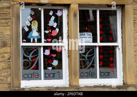 Honley, Holmfirth, Yorkshire, Großbritannien, 31. März 2021. Alice im Wunderland im Gallery Cafe Fenster, Teil des Honley Woven Book Trail. Mit umweltfreundlichen und recycelten Materialien, wie alte Kleidung/Stoffe, haben Dorfbewohner und Unternehmen eine Szene oder Charakter(en) aus einem Lieblingsbuch geschaffen, um in ihrem Garten oder Fenster zu zeigen, um einen lokalen Weg von Sonntag, 28. März bis Montag, 5. April zu schaffen. Diese Veranstaltung ist Teil des Huddersfield Literature Festival und es gibt Buchpreise für die Gewinner der Region und einen Literatur/Foodie-Korb für einen Gesamtsieger. RASQ Photography/Alamy Live News. Stockfoto