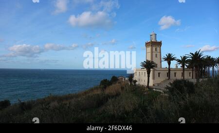 PHARE Cap Spartel Leuchtturm am Atlantik von Marokko bei Tanger. Umrahmt von Palmen und strahlend blauem Himmel. Stockfoto