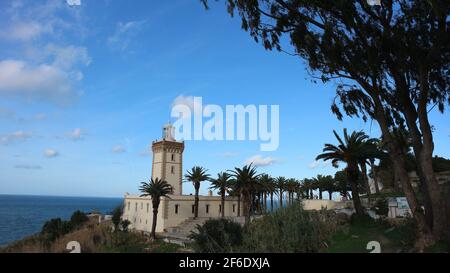 PHARE Cap Spartel Leuchtturm am Atlantik von Marokko bei Tanger. Umrahmt von Palmen und strahlend blauem Himmel. Stockfoto