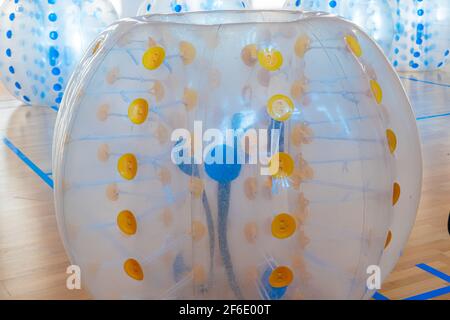 Ausrüstung für Teambuilding Sportspiel namens Bumper Ball oder Bubble Ball. Zorbsoccer. Orange Boll boll Luftballons im Sportzentrum. Stockfoto