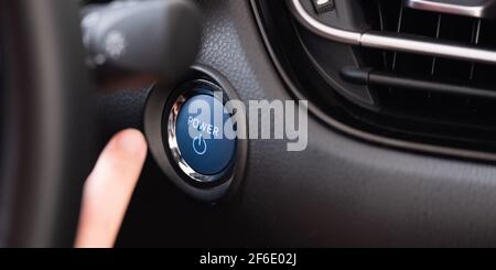 Frau, Die Den Motor-Start-Knopf Und Den Zündschalter Drückt Stockfoto