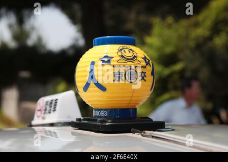 Detail eines der einzigartigen, bunten, gelben, Kunststoff-Dach Taxi Medaillon Lichter. In Kyoto, Japan. Stockfoto