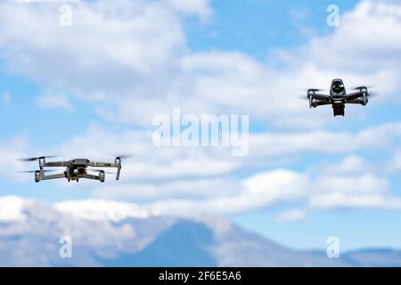 Zwei DJI-Drohnen fliegen an einem sonnigen Tag in der Nähe. DJI FPV ist eine bahnbrechende flugfertige FPV-Drohne. Stockfoto