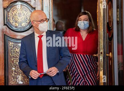 Hamburg, Deutschland. März 2021, 31st. Peter Tschentscher (SPD), erster Bürgermeister von Hamburg, und Katharina Fegebank (Bündnis 90/Grüne), zweite Bürgermeisterin von Hamburg, betreten vor Beginn einer Pressekonferenz zu den neuen Corona-Maßnahmen den Kaisersaal im Rathaus. Quelle: Georg Wendt/dpa/Alamy Live News Stockfoto