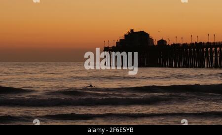 Oceanside, California USA - 16 Feb 2020: Surfer Silhouette, pazifik Strand am Abend, Wasserwellen und Sonnenuntergang. Tropische Küste, Waterfront vac Stockfoto