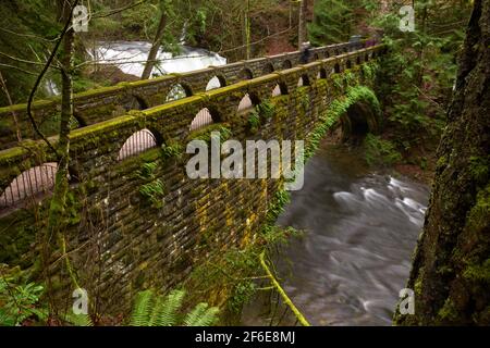 Historische Whatcom Falls Bridge, Washington State. Whatcom Creek und die historische Steinbrücke, die es überquert. Bellingham, Washington. Stockfoto