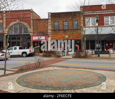 HENDERSONVILLE, NC, USA--23 MÄRZ 2021: Vier Personen sprechen vor den laufenden Bauarbeiten bei der D9 Brewing Company an der Main Street. Stockfoto