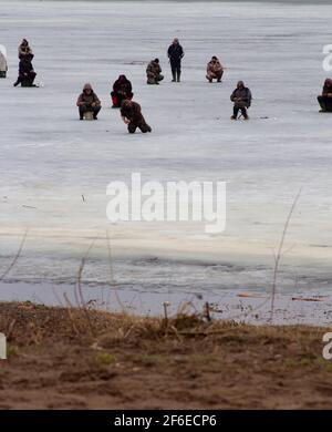 Im Frühjahr fischen die Fischer auf gefährlichem dünnem Eis. Stockfoto