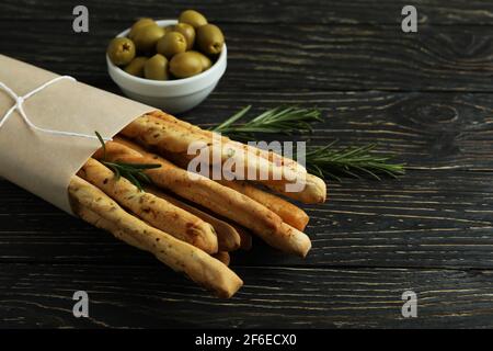 Bastelpapier mit Grissini, Oliven und Rosmarin auf Holzgrund Stockfoto