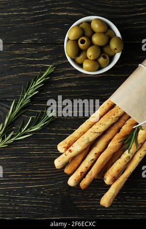 Bastelpapier mit Grissini, Oliven und Rosmarin auf Holzgrund Stockfoto